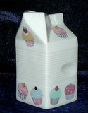Milk carton shaped jug off white ceramic decorated with colourful cupcakes